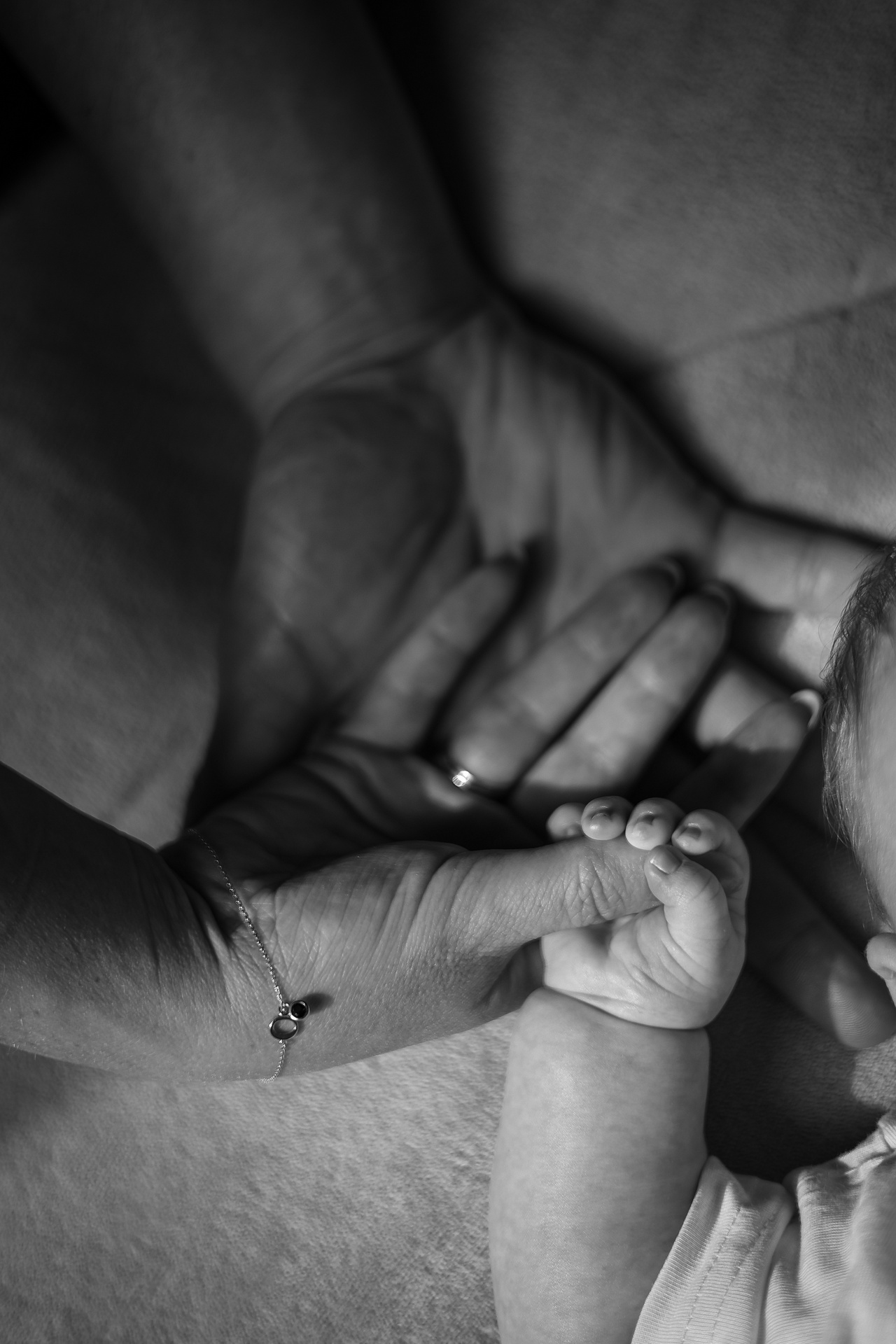 Close up zwar wit foto van babyhandje en handen van de ouders, newborn fotografie