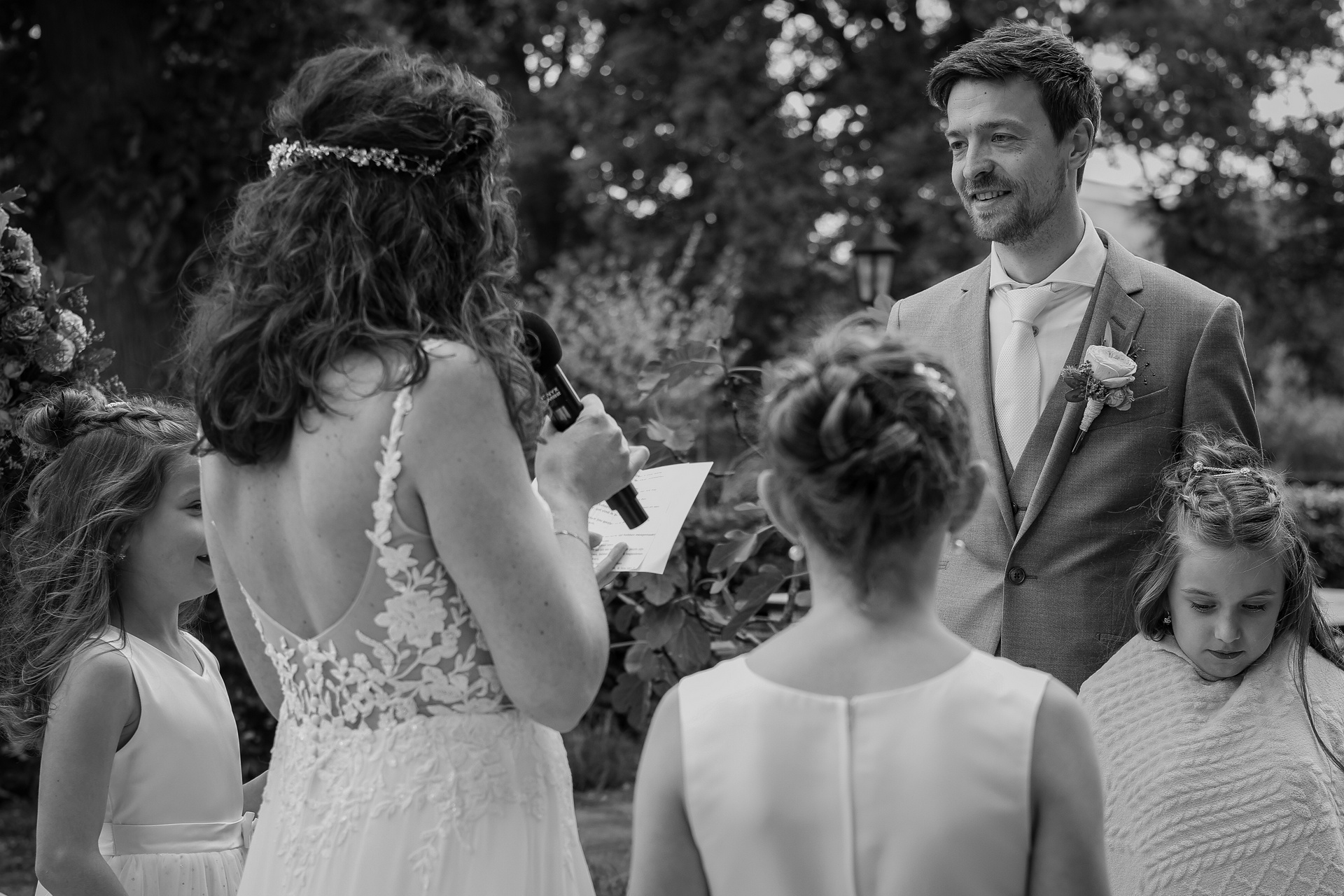 Foto van een bruidspaar, de bruid houdt een speech tijdens de ceremonie