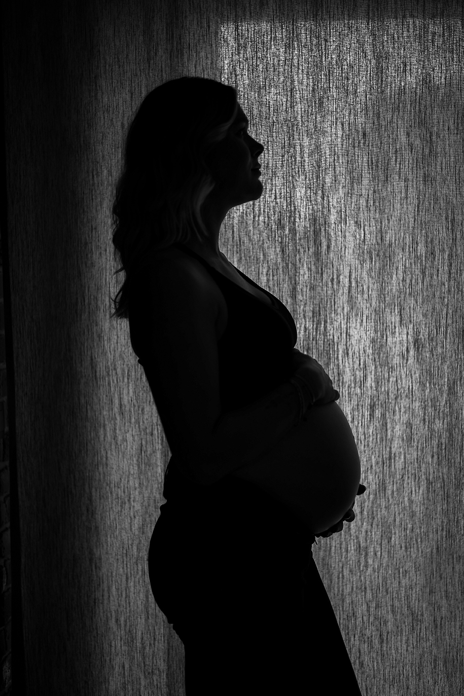 Silhouet foto van een zwangere vrouw. Zwangerschaps en newborn fotografie
