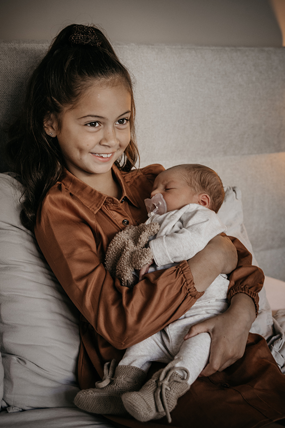 Foto van een grote zus met haar newborn broertje. newborn shoot
