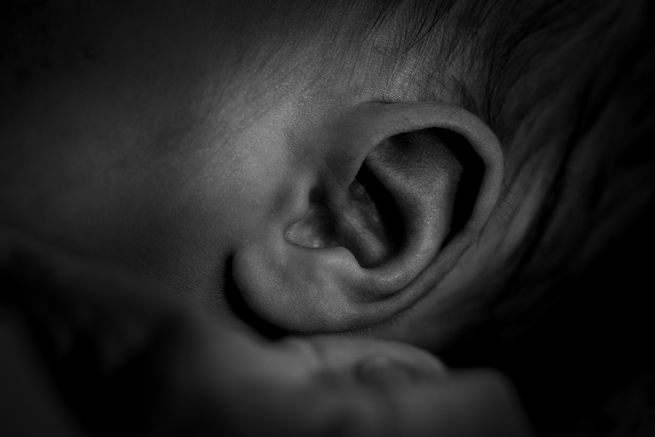 Zwart wit close up foto van een bay oortje, newbornshoot