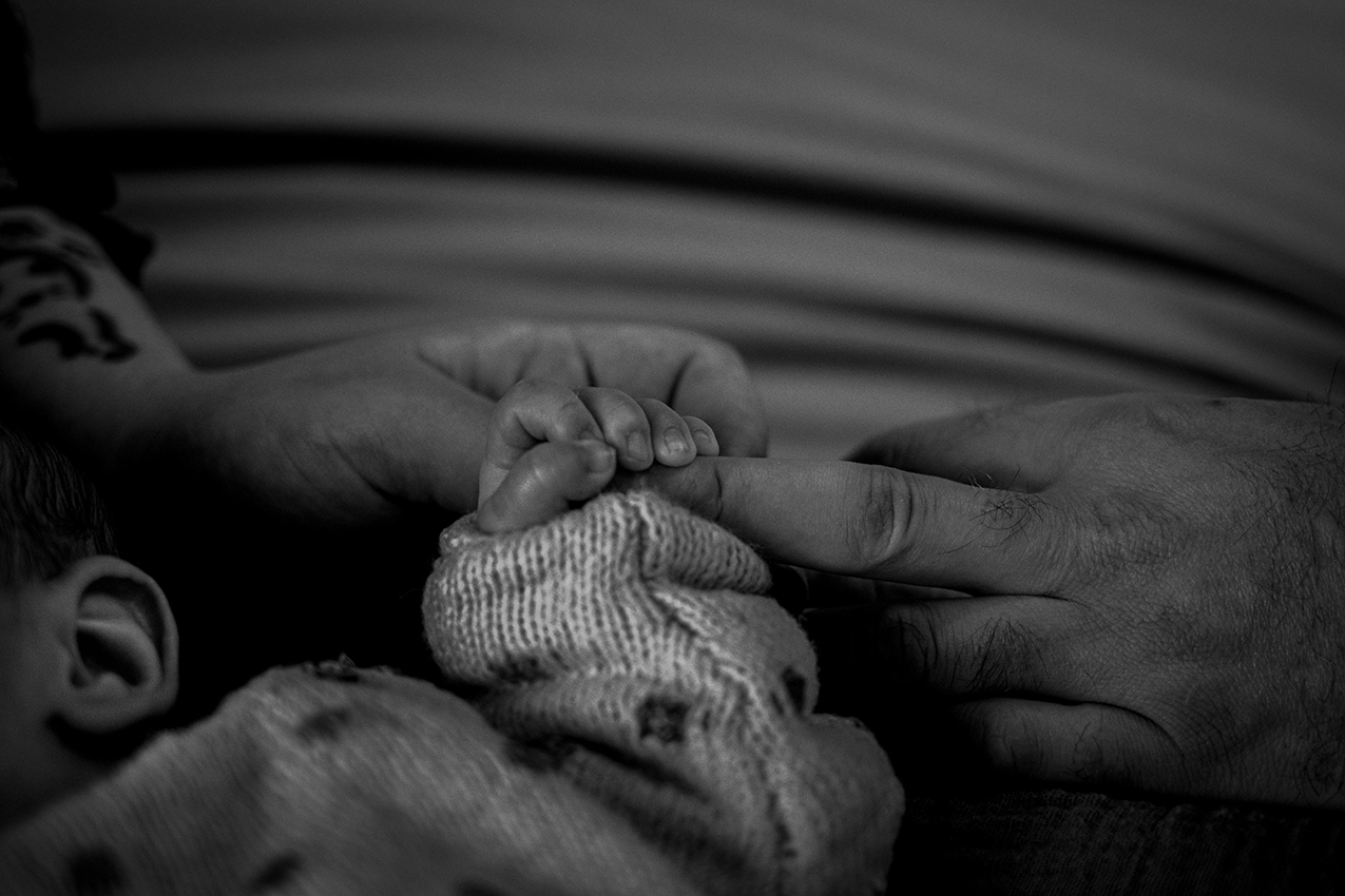 Close up van een baby handje die de vingen van zijn moeder vasthoudt, Tilburg